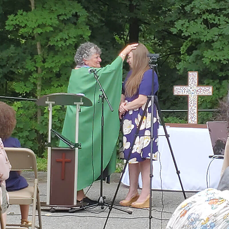 reverend martha performing baptism on young adult woman